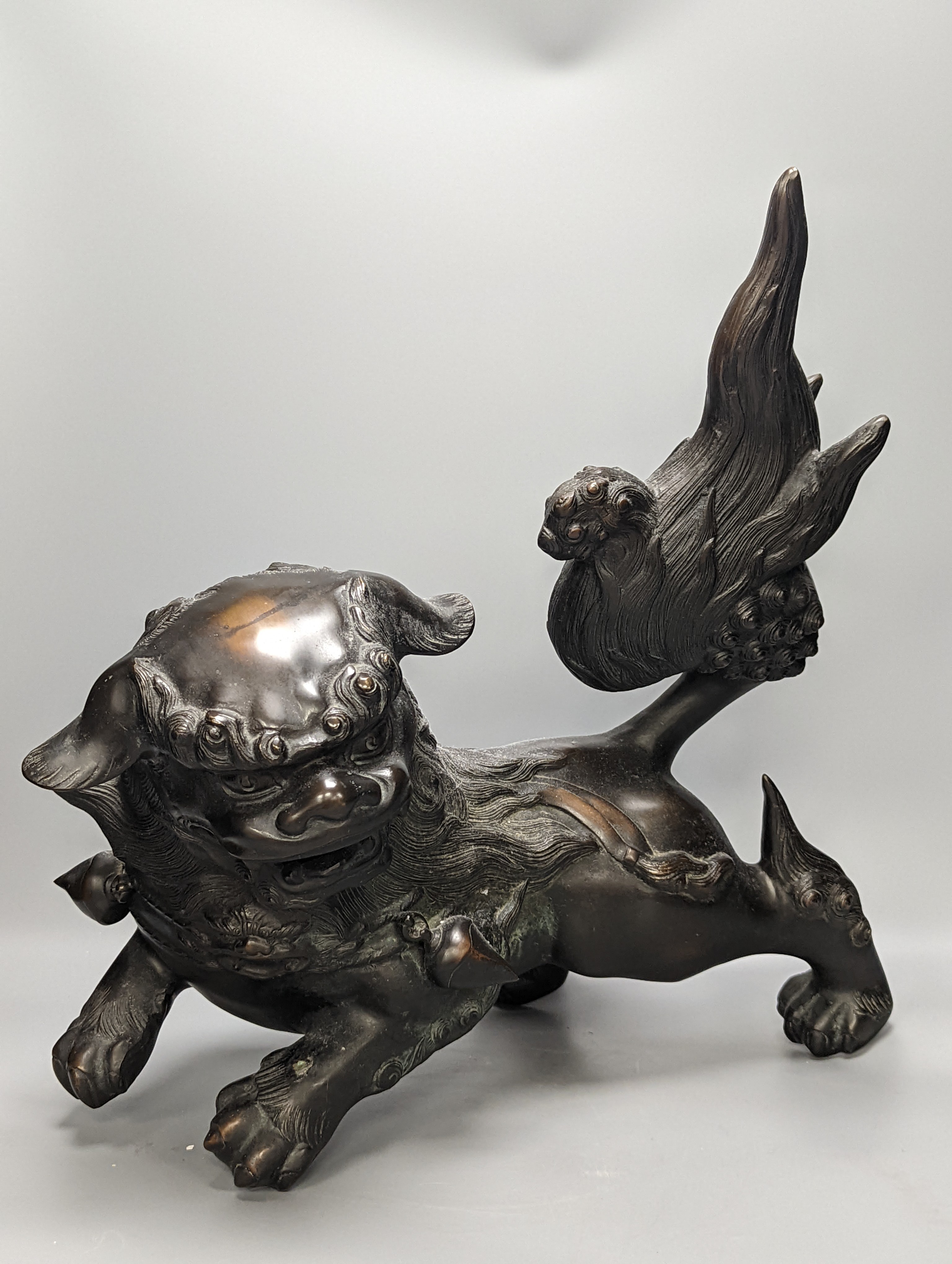 A large Chinese or Japanese bronze figure of a lion-dog or kara shi-shi, 45 cm long